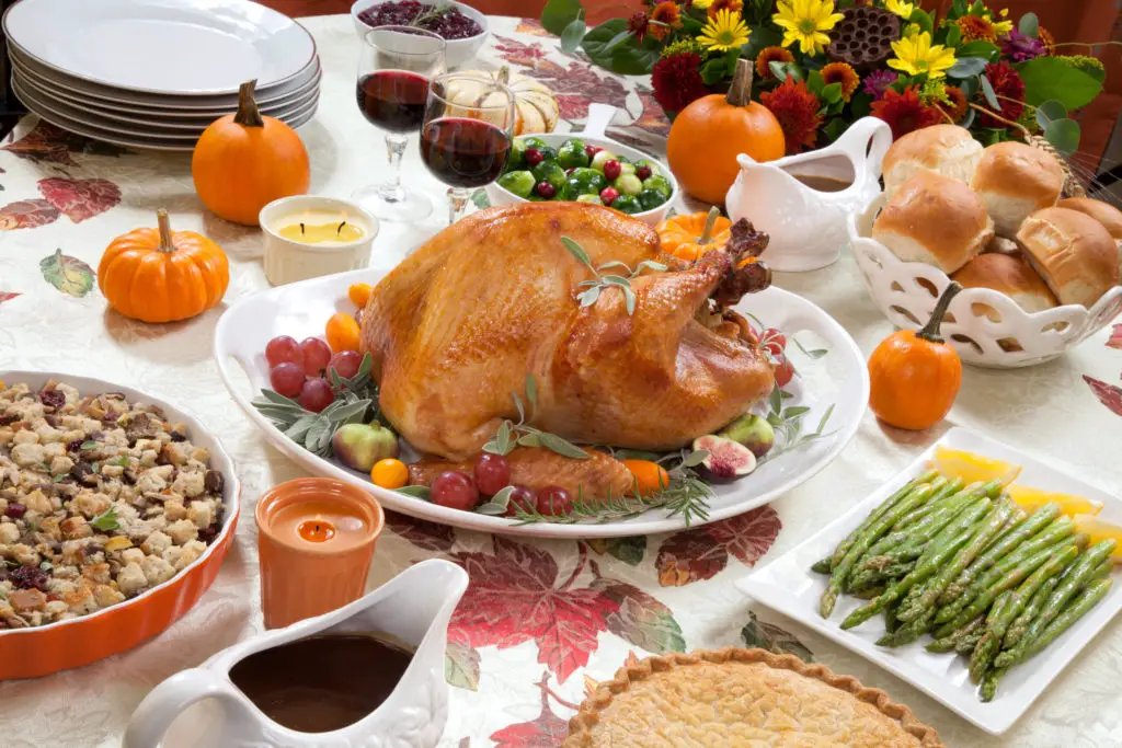 Thanksgiving dinner table with turkey and side dishes. Find out the best wine for Thanksgiving!